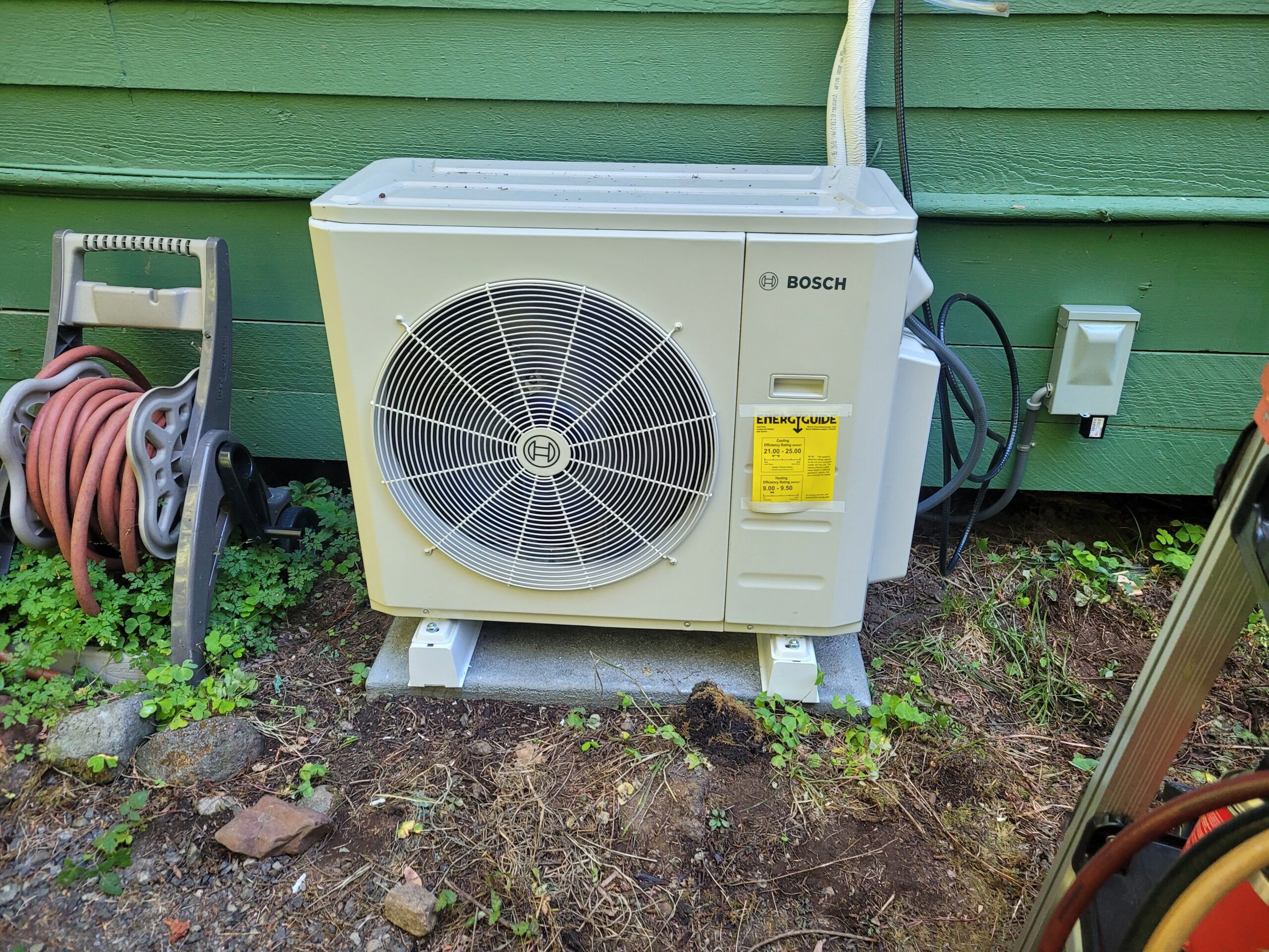 Bosch outdoor heat pump condenser installed on a concrete pad beside a Portland-area home
