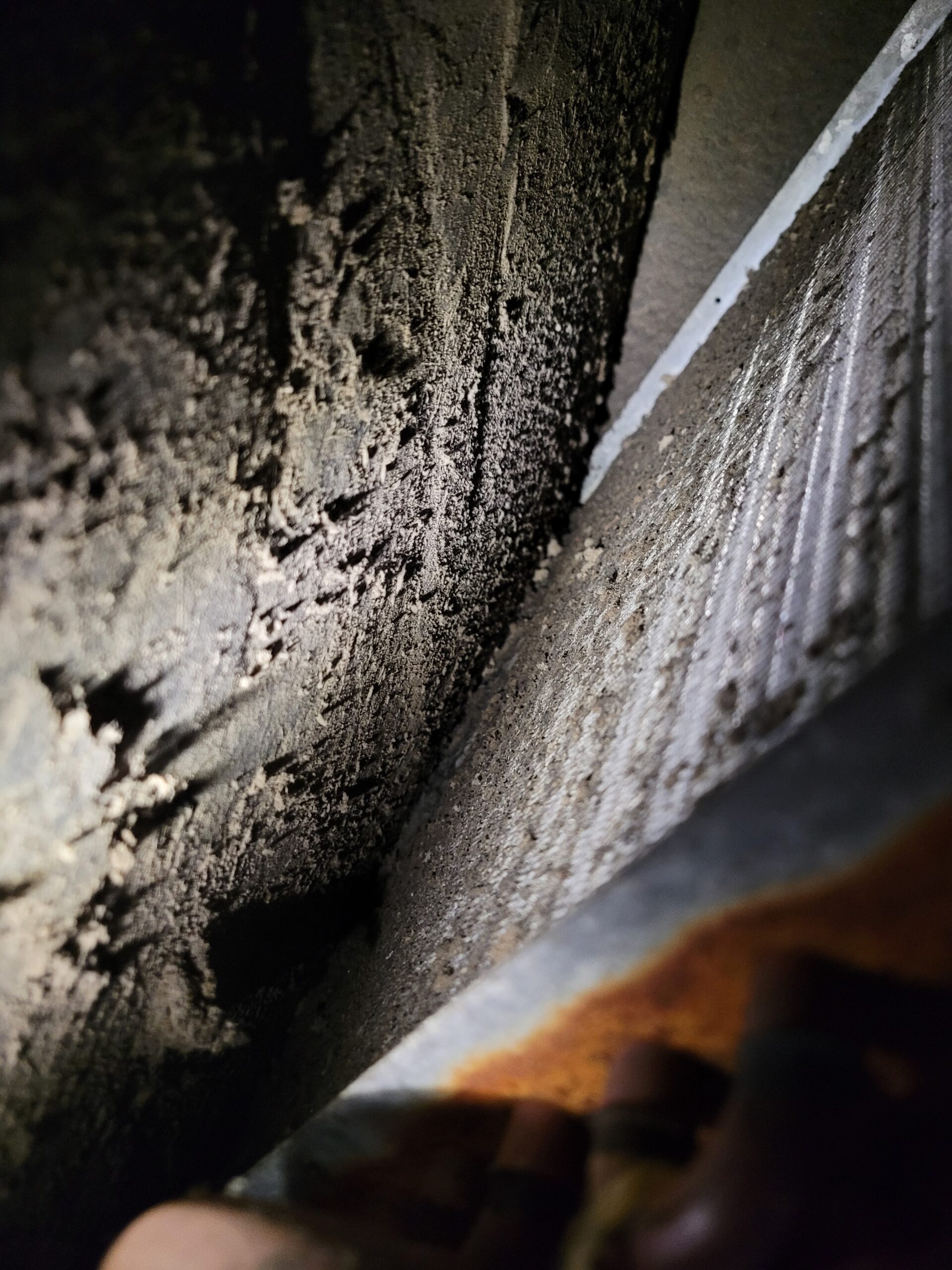 Close-up of a heavily dust-clogged HVAC evaporator coil with thick debris buildup between the fins