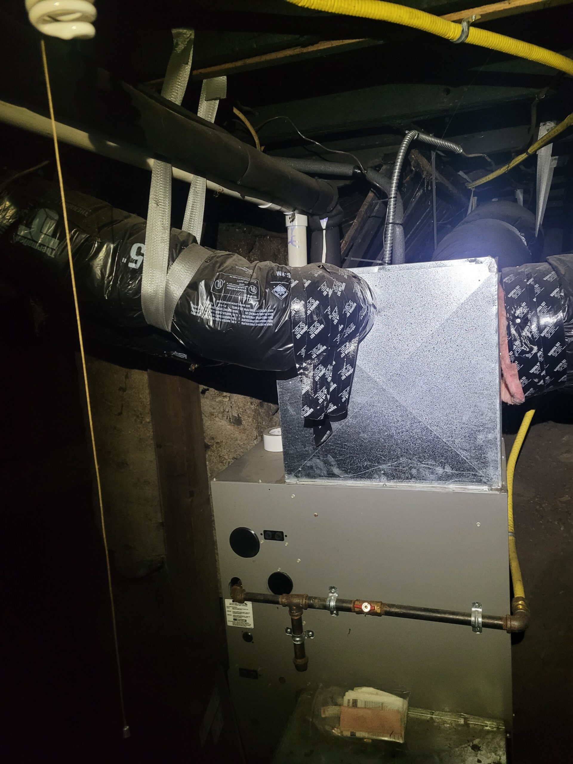Air handler installed in a crawlspace with insulated ductwork, copper refrigerant lines and condensate drain