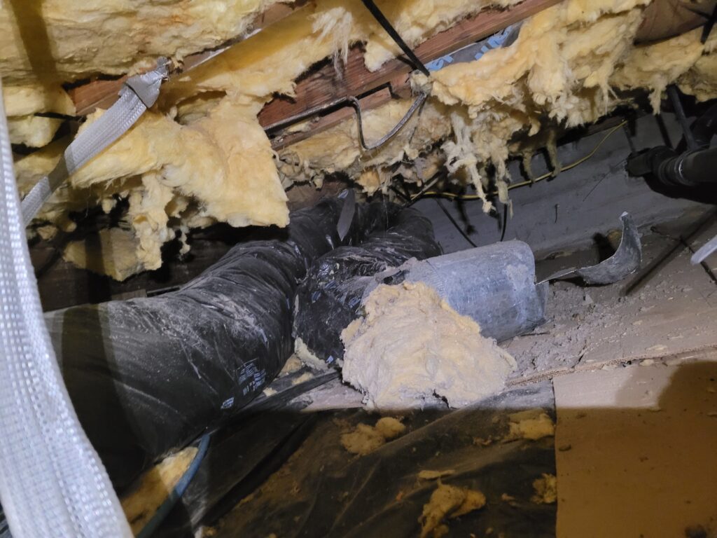 Disconnected duct run with insulation stuffed in the fitting, found in a Gresham crawlspace
